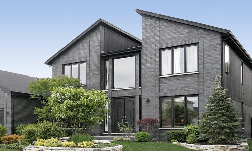 Modern home with gray brick and black door